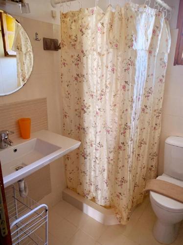a bathroom with a toilet and a shower curtain at Palma Sidari Corfu in Sidari