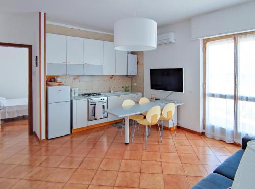 une cuisine avec des armoires blanches et une table et des chaises dans l'établissement Bella Vista - By Ligooria, à Pietra Ligure