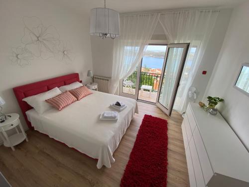 a bedroom with a bed with a red headboard and a red rug at Apartman Betty in Šibenik