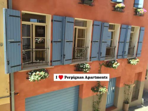 ein Gebäude mit blauen Fensterläden auf der Seite in der Unterkunft I Love Perpignan Apartments 10 in Perpignan