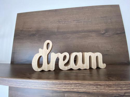 a wooden sign that says dream on a table at Apartman Betty in Šibenik