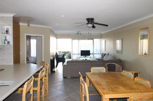 eine Küche und ein Wohnzimmer mit einem Tisch und einer Couch in der Unterkunft Corona Del Mar 13 in Margate