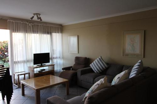 ein Wohnzimmer mit Sofa und Tisch in der Unterkunft Corona Del Mar 13 in Margate