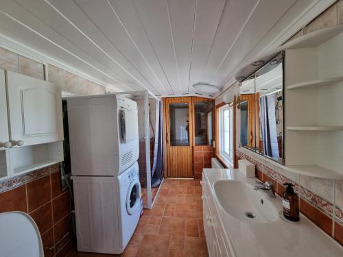 a kitchen with a washer and dryer and a sink at Byske Gästgivargård in Byske