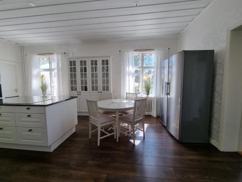 a kitchen with a table and a refrigerator at Byske Gästgivargård in Byske