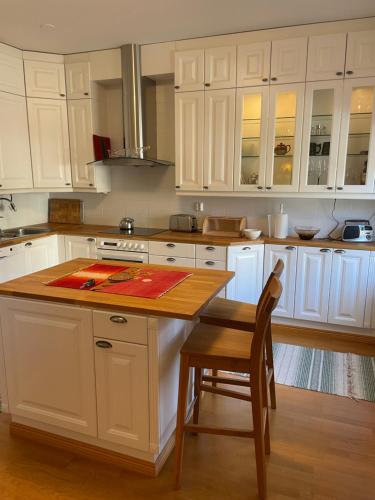 a kitchen with white cabinets and a wooden table at Kotka Pearl (Kotkan Helmi) in Kotka