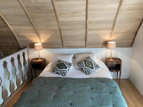 1 dormitorio con 1 cama con 2 lámparas en 2 mesas en L'annexe du Plessis Bochard en Saint-Pierre-des-Nids
