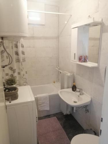un bagno bianco con lavandino e vasca da bagno di Apartman Centar Beograd a Belgrado