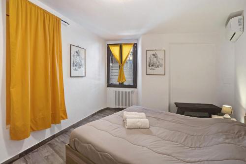 Appartamento Mameli في بافينو: غرفة نوم بسرير وستارة صفراء
