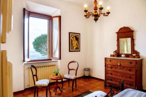 a dining room with a table and chairs and a window at Amazing Tuscany Window in Montemassi