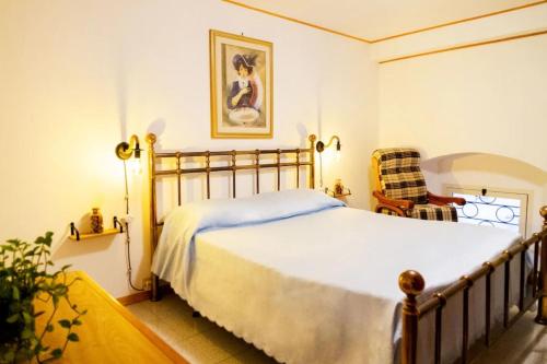 a bedroom with a bed and a chair at Amazing Tuscany Window in Montemassi