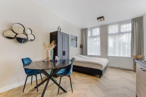 una camera con tavolo e letto e una camera da letto di Novallure Short Stay Apartments a Leidschendam