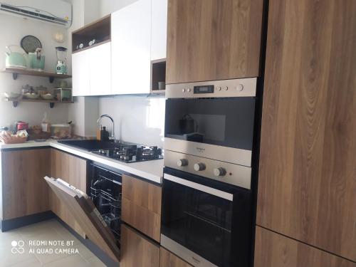 une cuisine avec des appareils en noir et blanc et des armoires en bois dans l'établissement APPARTAMENTO SANTUCCI, à Rodi Garganico