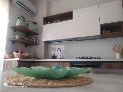 - une cuisine avec un bol vert sur un comptoir dans l'établissement APPARTAMENTO SANTUCCI, à Rodi Garganico