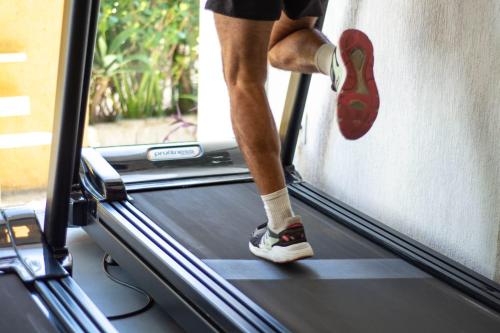 a person is walking on a treadmill at Hotel Pousada Casacolina in Búzios