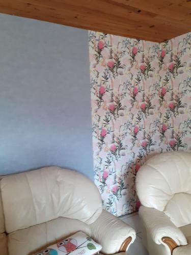 two white leather chairs in a room with a wallpaper at Le gite du hibou in Ménil-Hubert-sur-Orne