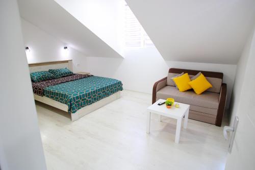 a bedroom with a bed and a couch and a table at Apartmani Hedonist in Soko Banja