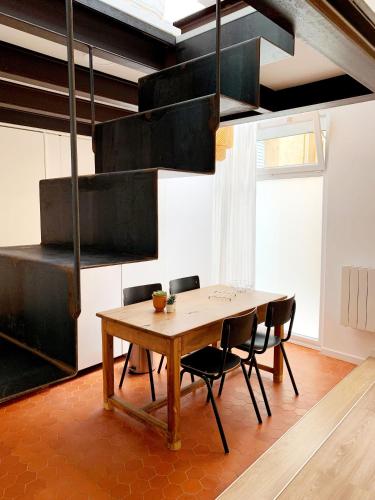 ein Esszimmer mit einem Holztisch und Stühlen in der Unterkunft L'atypique in Hyères