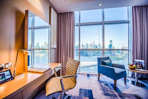 a living room with a large window overlooking the ocean at Canal Central Hotel in Dubai