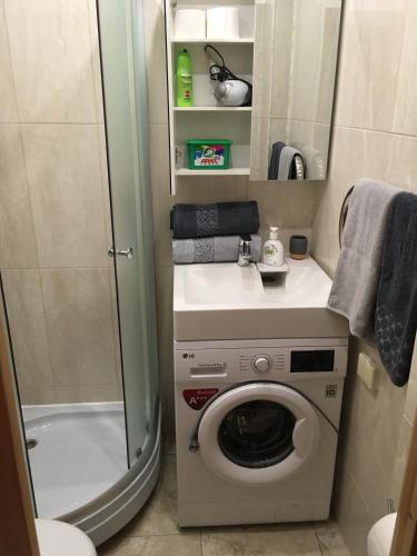 a washing machine in a bathroom with a shower at Apartment near the seaside in Jūrmala