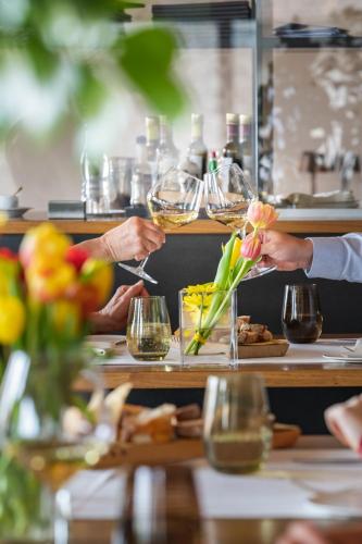 two people serving food at a table with glasses of wine at Conca Bella Boutique Hotel & Wine Experience in Vacallo