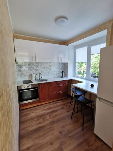 a kitchen with white cabinets and a table with chairs at Apartment near the seaside in Jūrmala