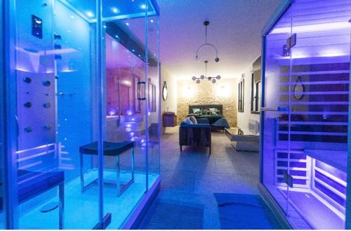 um quarto com uma sala de vidro com um quarto em L'indiscrete Love Room - Hammam-Sauna-SPA em Saint-Cyr-sur-Loire