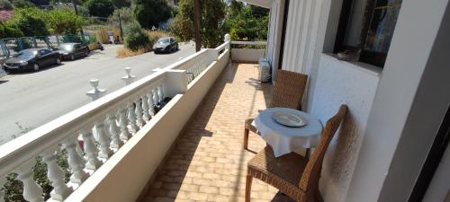 a balcony with a table and chairs and a street at Ixian House Apartment in Ixia
