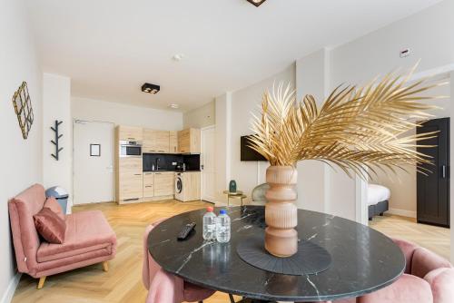 a living room with a table and a pink chair at Novallure Short Stay Apartments in Leidschendam
