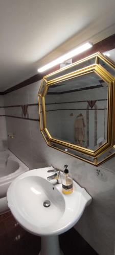 a bathroom with a white sink and a mirror at Ixian House Apartment in Ixia