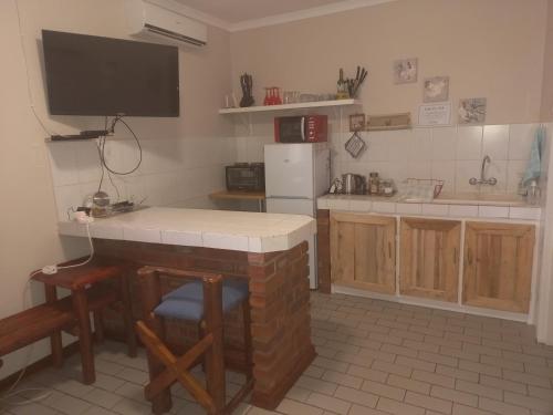 a kitchen with a counter and a tv on the wall at ChriZelo Self Catering unit in Upington