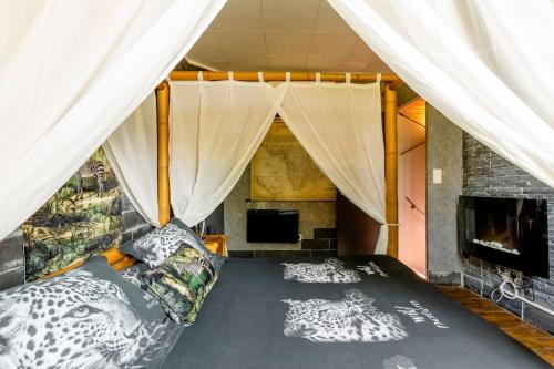 a bedroom with a bed with a mosquito net at Havre de paix Avignon avec Jacuzzi & Sauna in Avignon