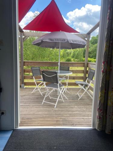 patio con tavolo, sedie e ombrellone di domaine des planesses a Ferdrupt