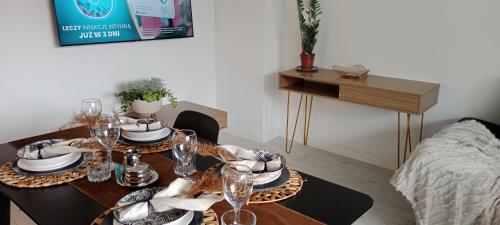 a table with glasses and plates on it in a room at Tabago Studio in Opole