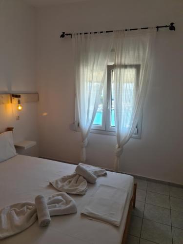 a bed with towels on it with a window at Mar Adentro in Patitiri