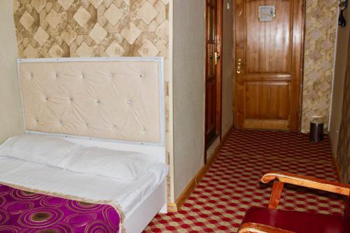 a bedroom with a bed and a wooden door at City Hostel & Tours in Ulaanbaatar