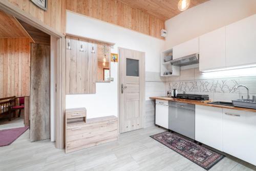 a kitchen with white cabinets and wooden walls at Willa Ewa in Jastarnia