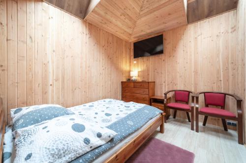 a bedroom with a bed and a desk and two chairs at Willa Ewa in Jastarnia