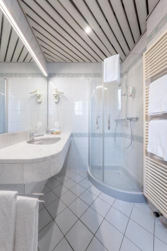 a white bathroom with a shower and a sink at Conca Bella Boutique Hotel & Wine Experience in Vacallo