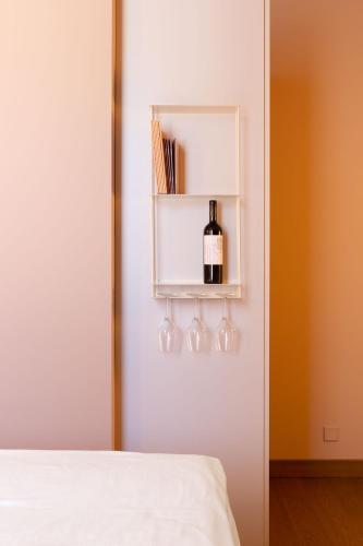 a bedroom with a bottle of wine on a shelf at Conca Bella Boutique Hotel & Wine Experience in Vacallo