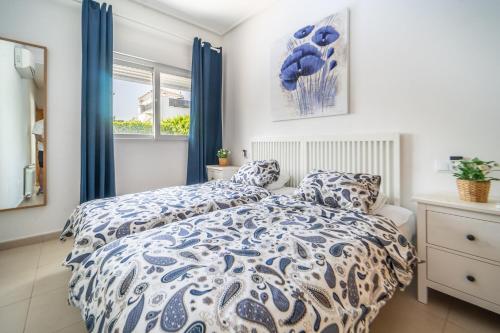 Un dormitorio con una cama con un edredón azul y blanco. en Villa with Private Pool - LO4LT, en Torre-Pacheco