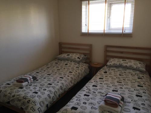 dwa łóżka siedzące obok siebie w sypialni w obiekcie Widemouth Waves Holiday Chalet w mieście Poundstock