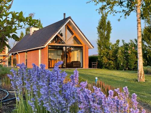 a house with purple flowers in front of it at -NIEUW- Luxe & sfeervol Vakantiehuis Tholen in Tholen