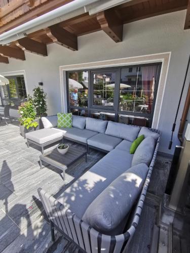a blue couch sitting on a patio at Hotel Landhaus Zillertal in Fügen