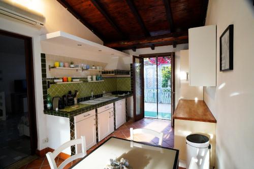 una cocina con armarios blancos y una mesa. en Villa Piri, en Sabaudia