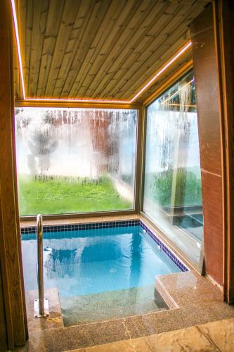 a swimming pool in a house with a window at Titanic Hotel & SPA in As Sulaymānīyah
