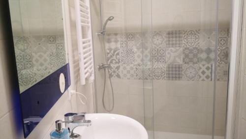 y baño con ducha y lavabo blanco. en Apartamento La Galatea, en Alcalá de Henares