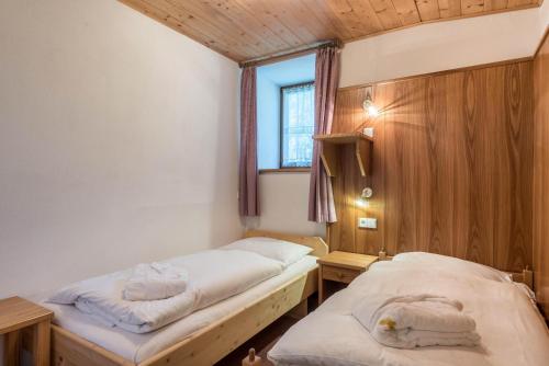 two beds in a room with a window at Ferienparadies Sabina Santner in Alpe di Siusi
