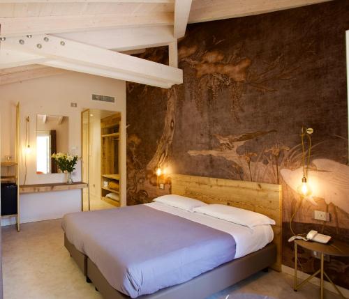 een slaapkamer met een groot bed en een muurschildering bij Hotel Vittorio in Desenzano del Garda