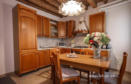 een keuken met een tafel met een vaas met bloemen erop bij Sole e Vento in Chioggia